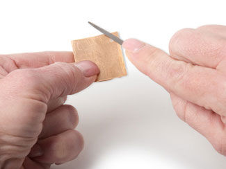 Metal square being filed